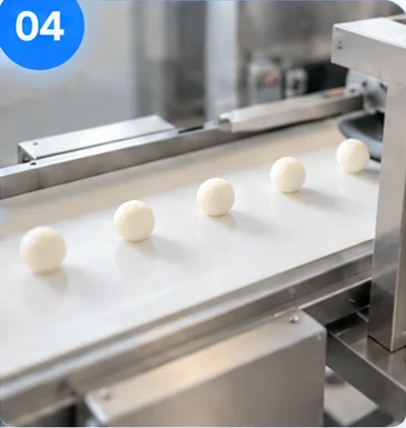 Finished balls discharged onto a conveyor